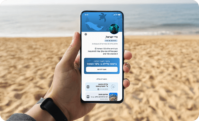 A hand holding a phone showing the Dolphin app home screen on a beach